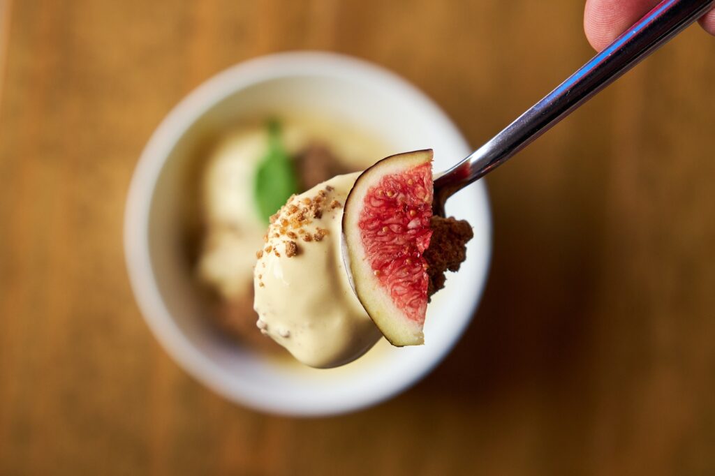 Aerial photo of a spoon with a fig grabbed from a dish of prickl